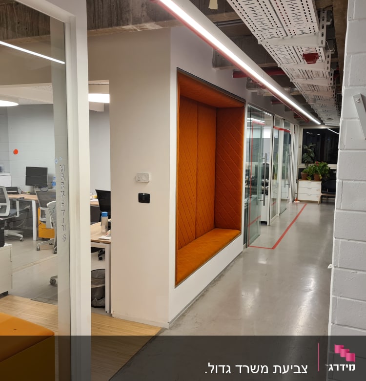 מסדרון משרדי עם ספסל כתום בקיר